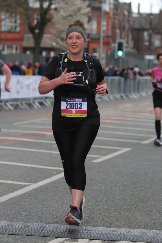 Jo Murray crossing the finish line of Manchester Marathon 2022